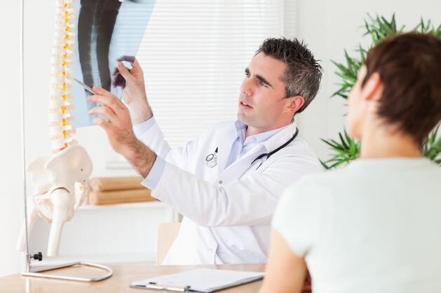 lékař ukazuje poškození páteře v důsledku cervikální osteochondrózy